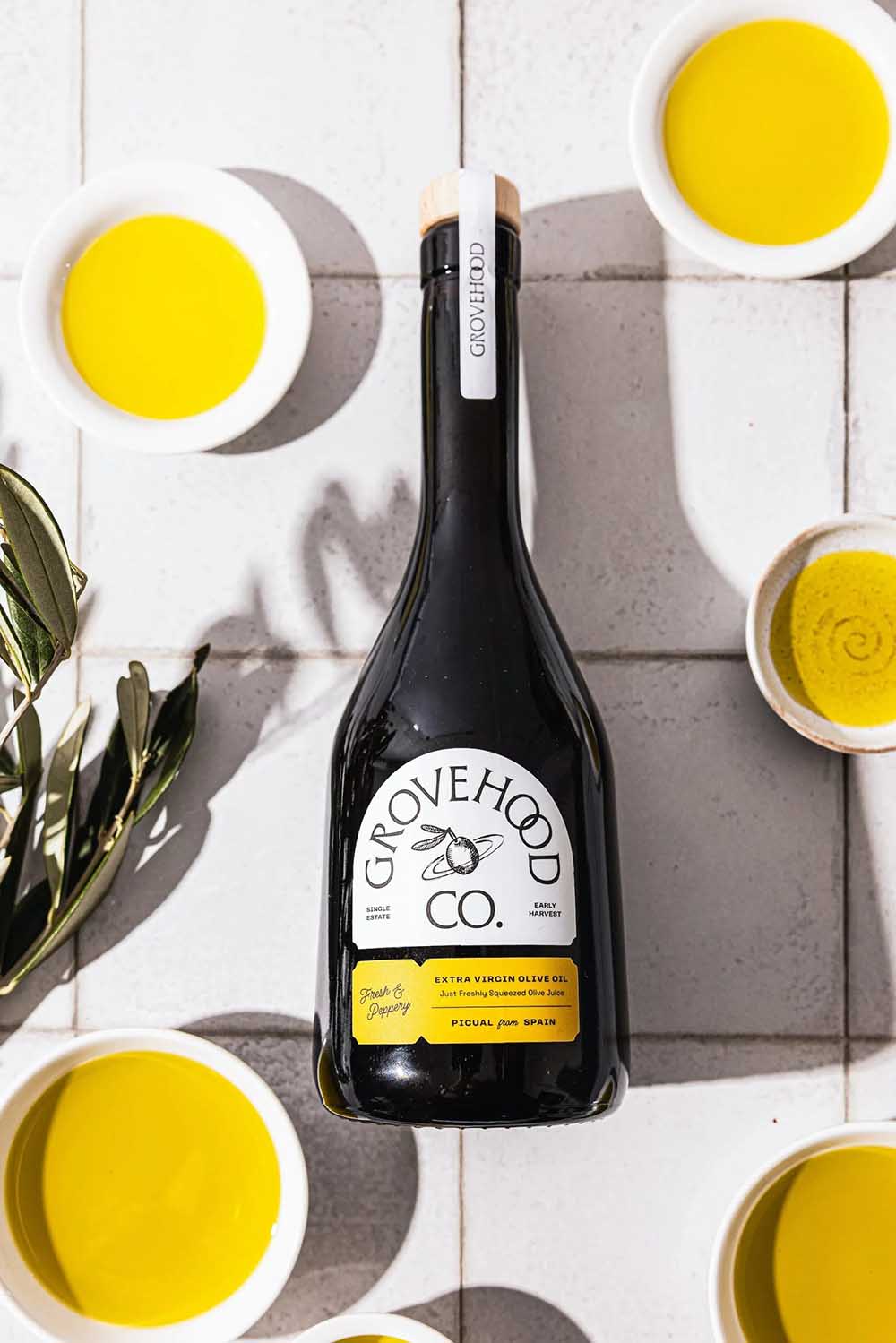 Botella de aceite de oliva Grovehood Collective con etiqueta troquelada y diseño de inspiración vintage