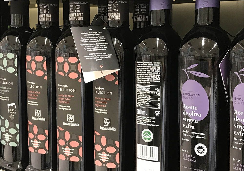botellas de aceite de oliva en un lineal de un supermercado