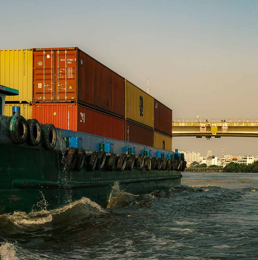 Barcaza cargada de contenedores navegando por el río Saigón en Ciudad Ho Chi Minh